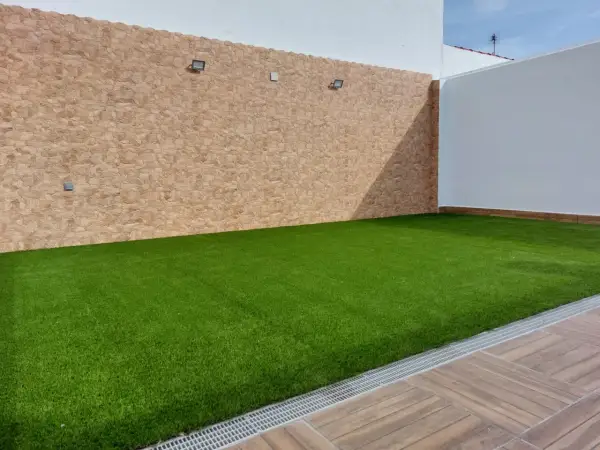 Césped artificial verde vibrante sobre una base impecable, ideal para crear tu oasis.